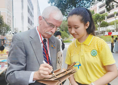 飞虎队老兵后人兰迪·斯科特为广西柳州市壶西实验中学学生留言。 　　本报记者 祝佳祺摄